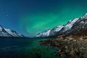 Image of the northern lights over lake with mountains