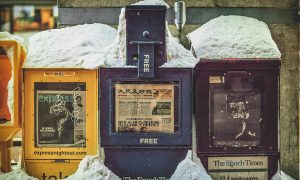 Image of street newspaper vending machines in Washington, DC in the snow