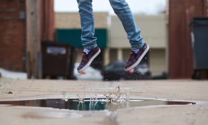 Image of a person jumping in a rain puddle