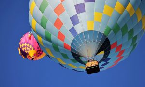 Image of two hot air balloons against clear blue sky