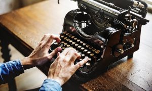 Image of a someone typing on a vintage typwriter