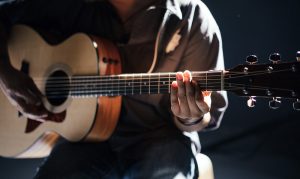 Image of someone playing an acoustic guitar