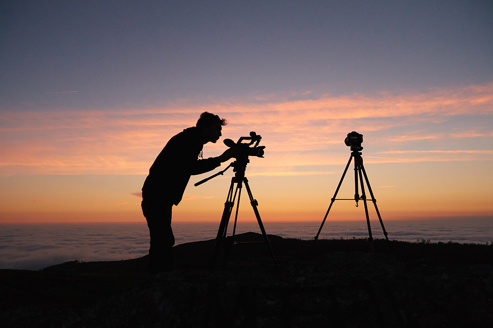 Image of a person filming outdoors during sunset