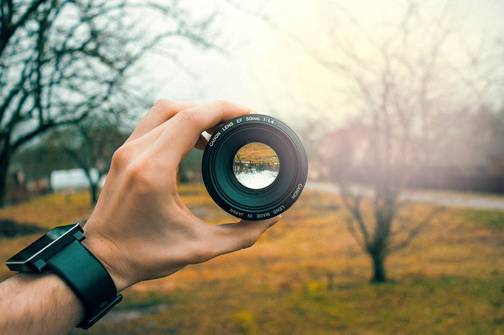 Image of camera lens focused on outdoor landscape